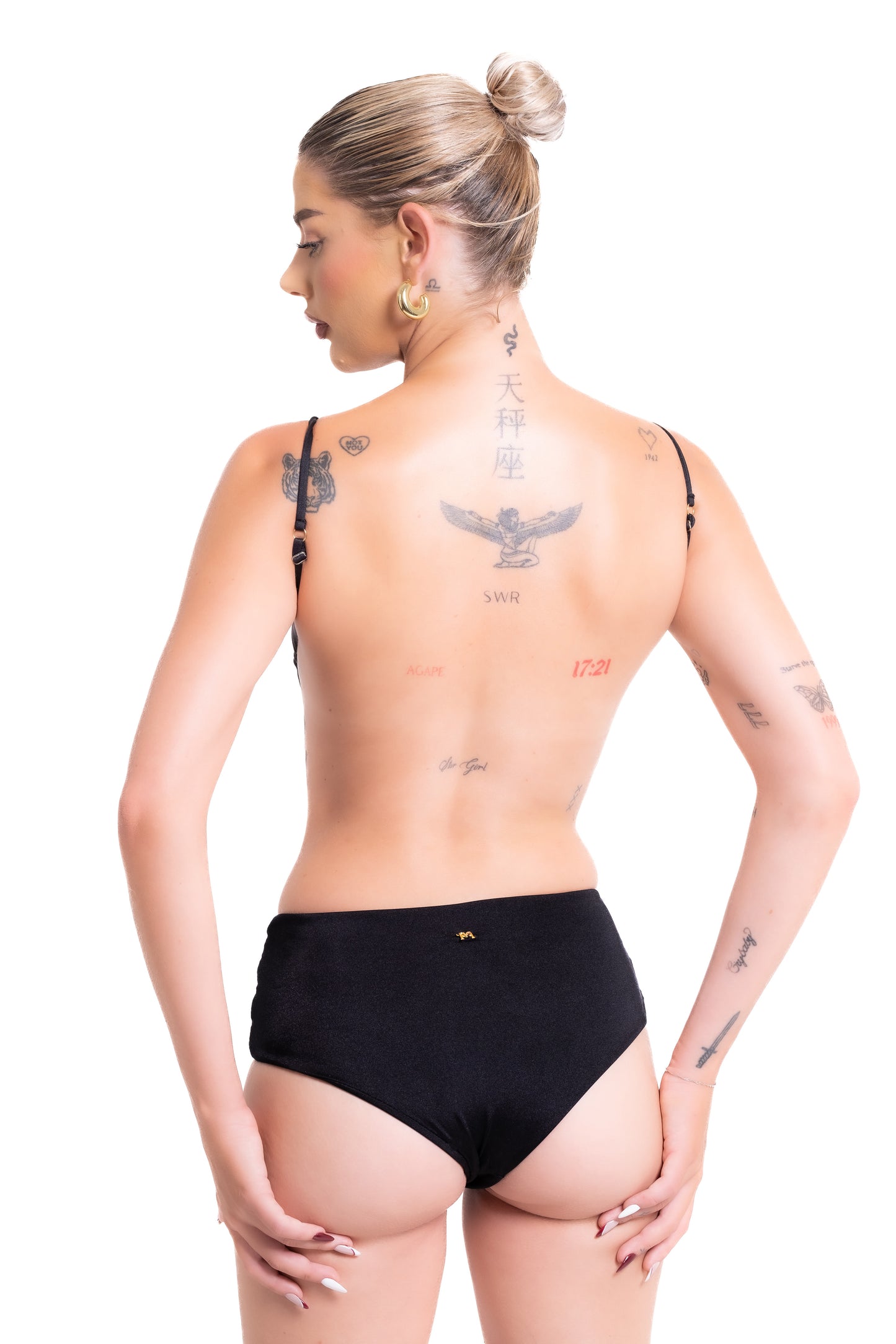 Woman wearing black underwear with a plain background
